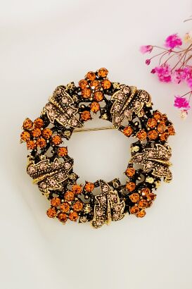 Broszka w kształcie wianka w pomarańczowej kolorystyce